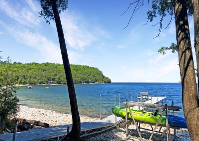 The beach and dock at Cove, with kayak rack in the foreground